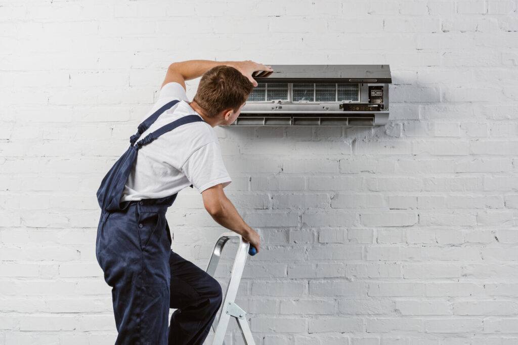 AC Repair in Truckee, CA 1 A man repairs an air conditioner, focused on fixing the unit.